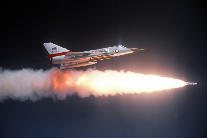 An air-to-air right side view of an F-106 Delta Dart aircraft after firing an ATR-2A missile over a range.  An auxiliary fuel tank is on each wing.  The aircraft is assigned to the 194th Fighter Interceptor Squadron, California Air National Guard. (U.S. Air Force Photograph/Released)