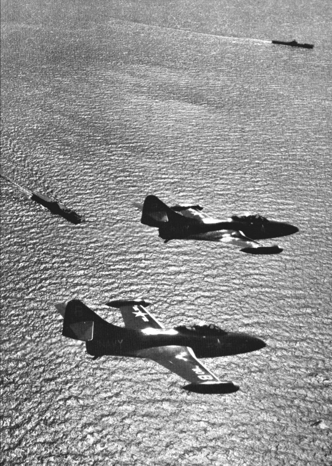 Two U.S. Navy Grumman F9F-2 Panthers of Fighter Squadron VF-191 "Satan's Kittens" return to the aircraft carrier USS Princeton (CV-37), visible in the foreground below. VF-191 was assigned to Carrier Air Group 19 (CVG-19) for a deployment aboard the Princeton from 9 November 1950 to 29 May 1951. In the background is USS PHilippine Sea (CV-47), which was deployed to Korea from 5 July 1950 to 9 June 1951 with CVG-11 and CVG-2. (Official Naval Historical Center photo)